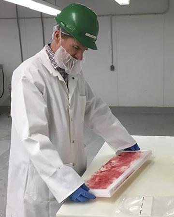 A scientist removes the sampling cloth from a continuous sampling device sampling cassette