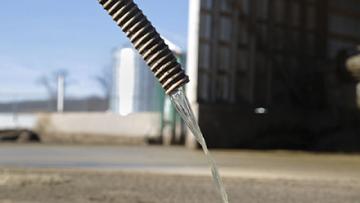 Almost clear water pours from a hose after processing in the MAPHEX system