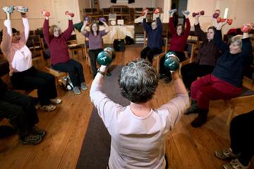 Older adults exercising with hand weights. 