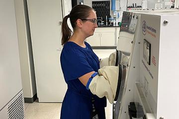 ARS molecular biologist Karley Mahalak in front of an anaerobic chamber 