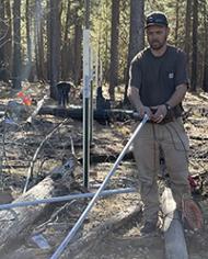 Dr. Jackson Leondard  installing an electrical conduit to protect soil moisture sensor cables from animal and weather damage.