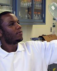 Adelumola Oladeinde holding a petric dish of E. coli  recovered from broiler chickens.