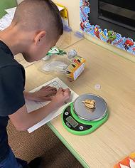 A young boy writing on a sheet of paper.